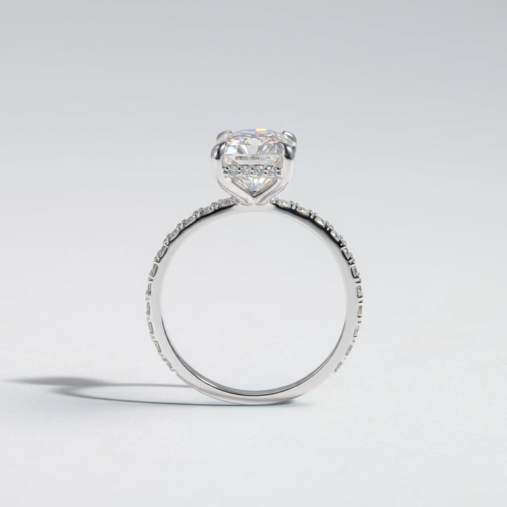 A silver-toned heart-shaped diamond engagement ring with a pavé band, photographed on a clean light gray background #material_white