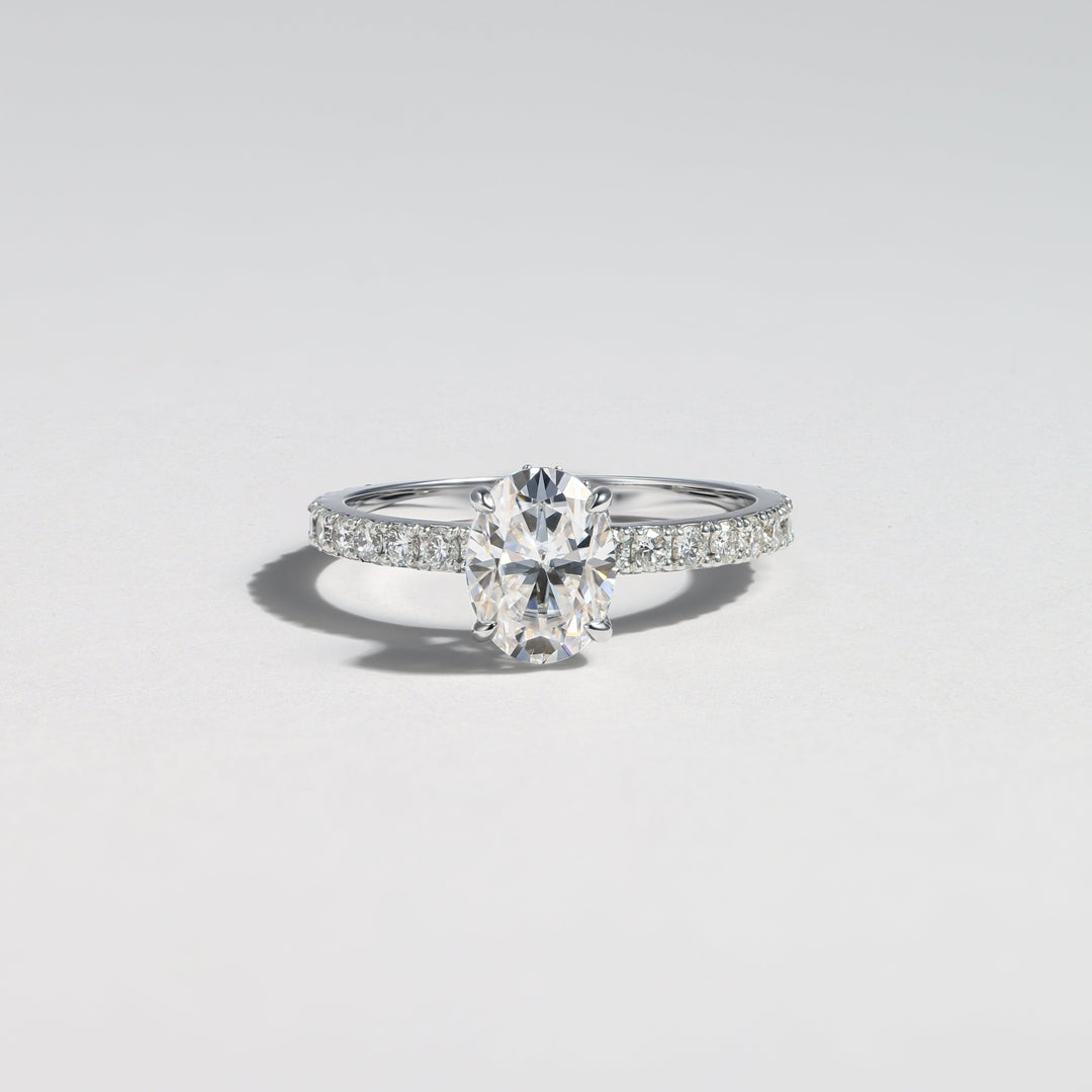 A silver engagement ring featuring a marquise-cut center stone and pavé-set side stones, photographed on a clean light gray background #material_white