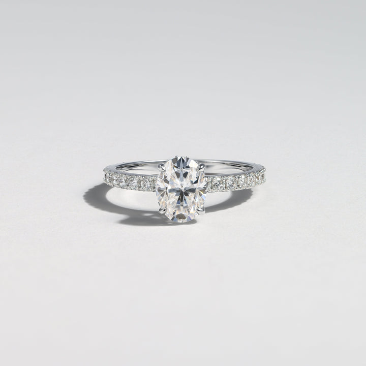 A silver engagement ring featuring a marquise-cut center stone and pavé-set side stones, photographed on a clean light gray background #material_white