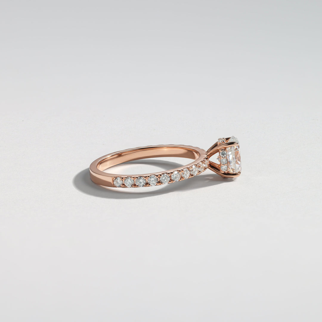 A rose gold diamond ring with a pavé band and a central marquise-cut diamond, photographed on a clean light gray background #material_rose