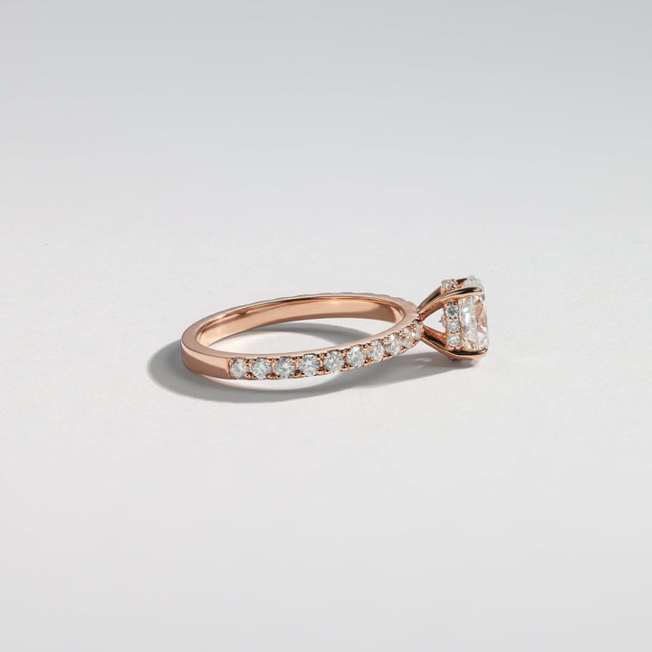 A rose gold diamond ring with a pavé band and a central marquise-cut diamond, photographed on a clean light gray background #material_rose