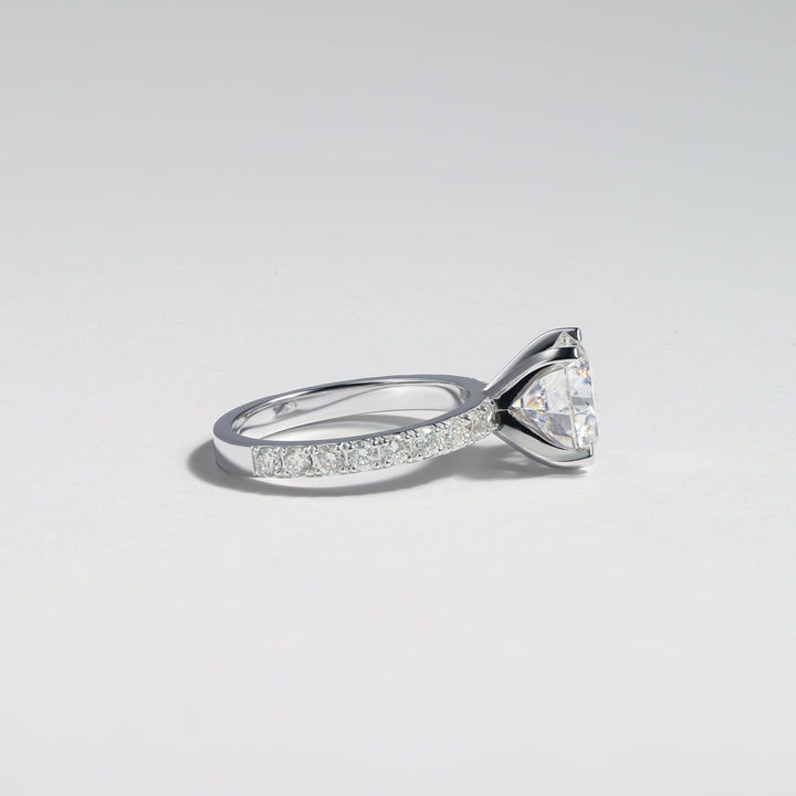 A silver-toned diamond ring with a triangular cluster of clear stones and a pavé band, photographed on a clean light gray background #material_white