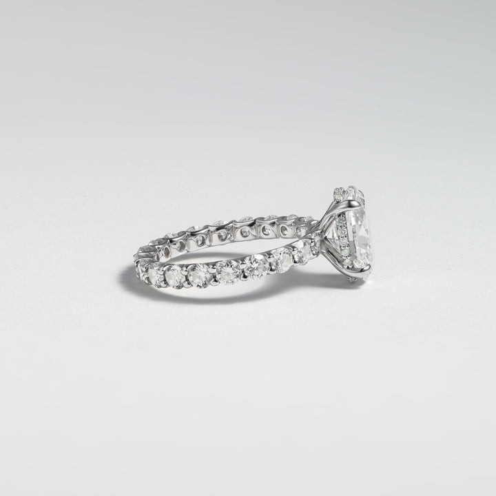 A silver-toned diamond ring with a triangular-cut center stone and a pavé band, photographed on a clean light gray background #material_white