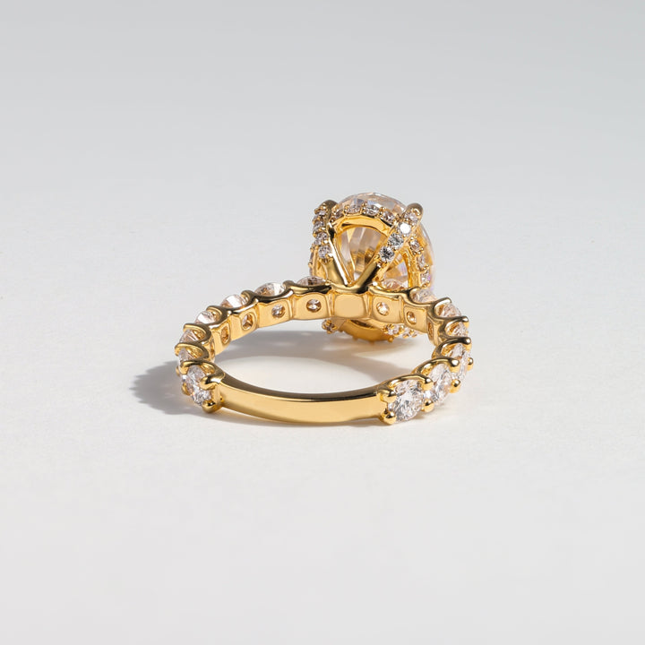 A gold ring with a pavé-set clear crystal crown and a matching crystal-accented band, photographed on a clean light gray background #material_gold