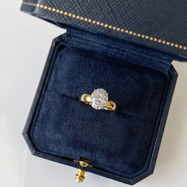 Gold ring with a diamond in a blue jewelry box on a white background#material_gold