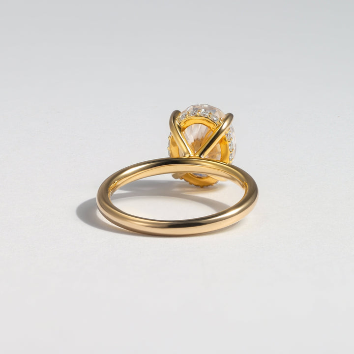 A gold ring with a unique twisted band and a bezel-set diamond, photographed on a clean white background #material_gold