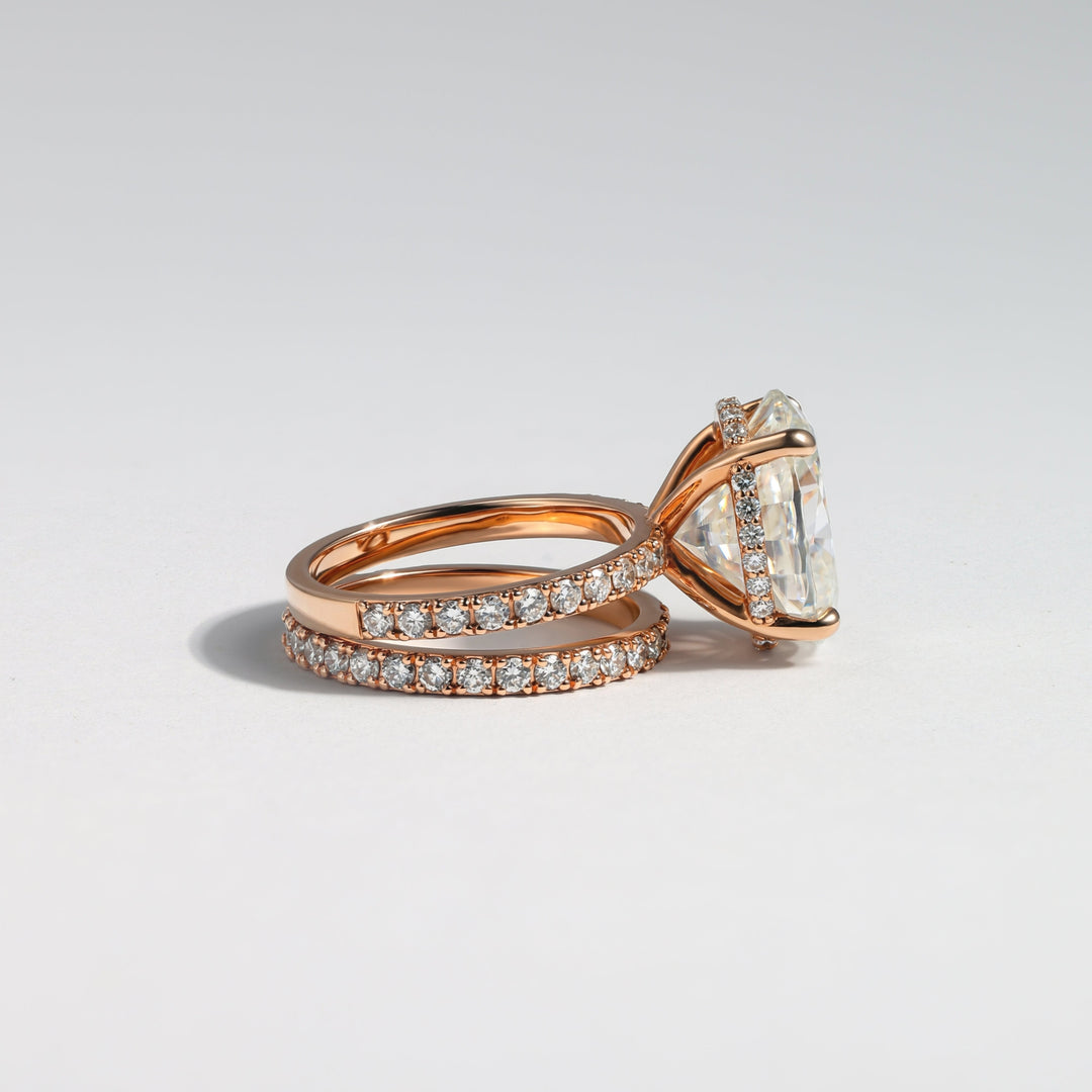 A rose gold engagement ring with a large oval-cut center stone and a matching pavé band, photographed on a clean light gray background #material_rose