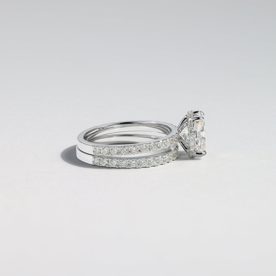 A silver-toned diamond ring with a large triangular center stone and pavé-set side stones, photographed on a clean light gray background #material_white
