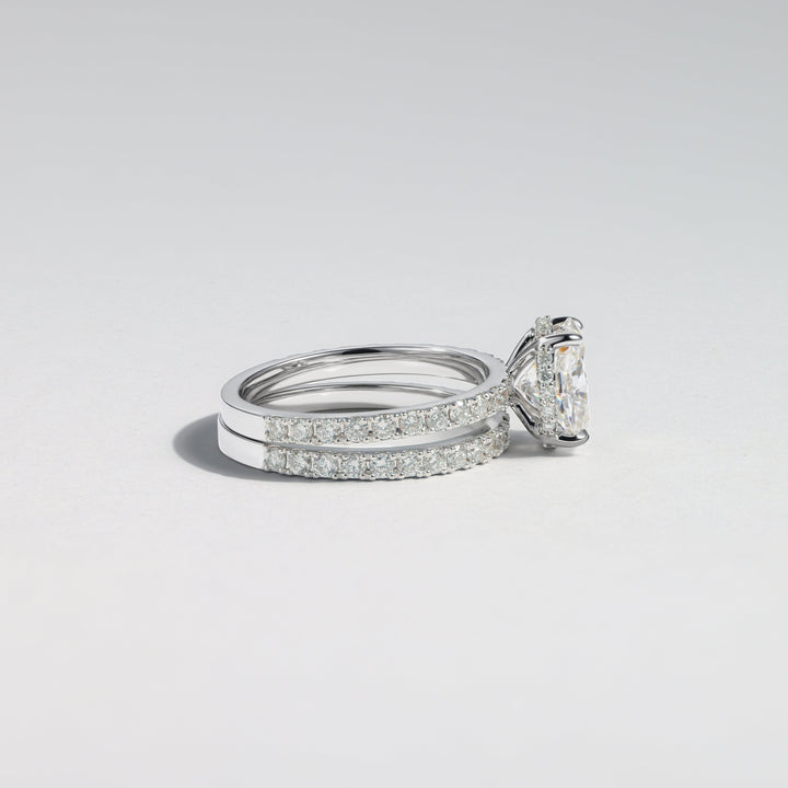A silver-toned diamond ring with a large triangular center stone and pavé-set side stones, photographed on a clean light gray background #material_white