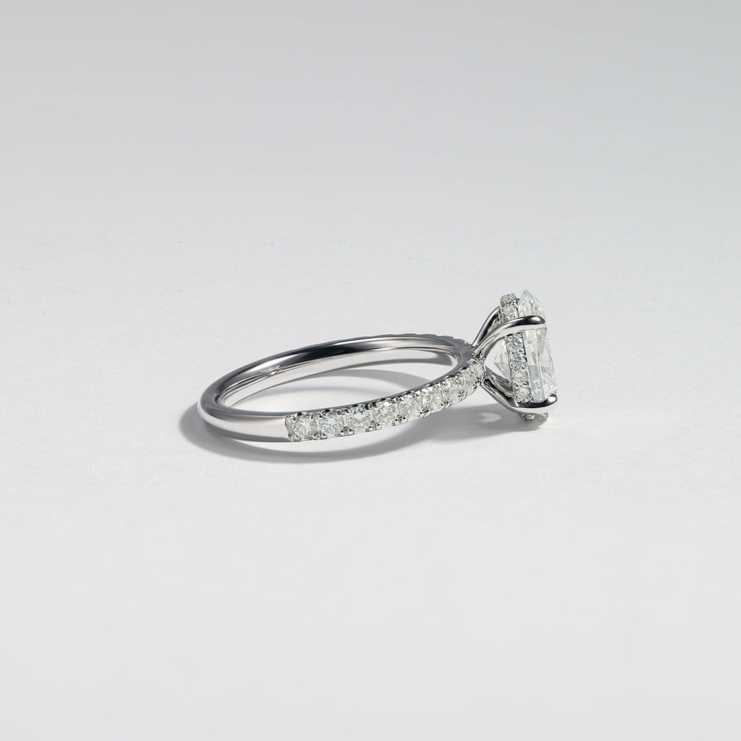 A silver-toned diamond ring with a marquise-cut center stone and pavé-set diamonds along the band, photographed on a clean light gray background #material_white