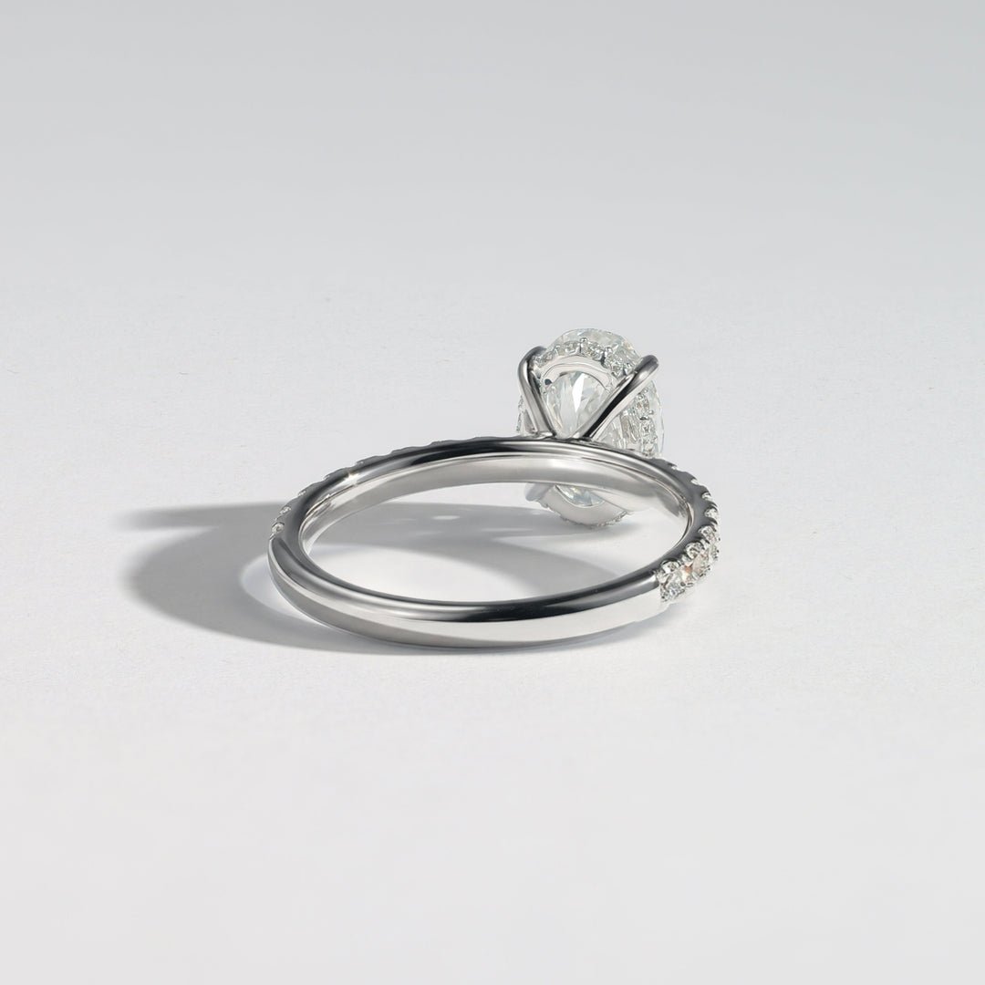 A silver-toned diamond ring with a marquise-cut center stone and pavé-set diamonds along the band, photographed on a clean light gray background #material_white