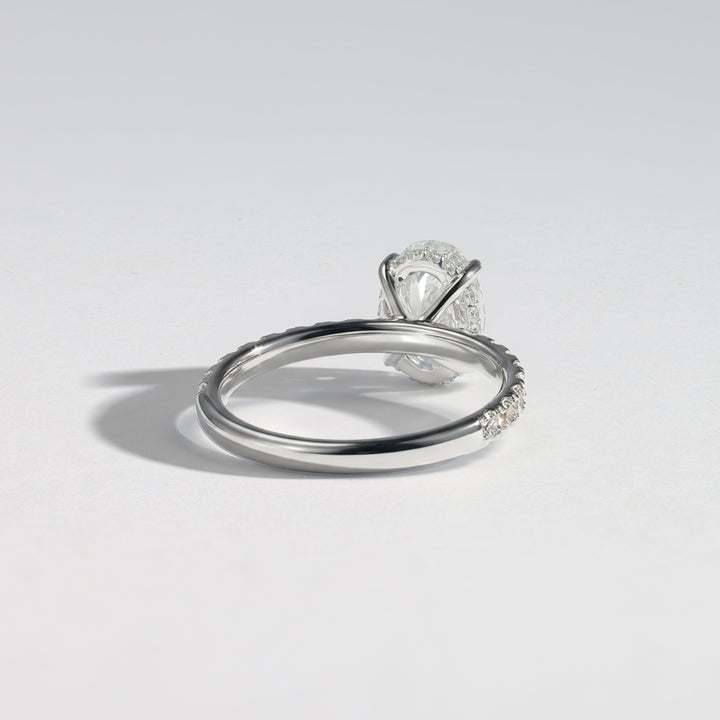 A silver-toned diamond ring with a marquise-cut center stone and pavé-set diamonds along the band, photographed on a clean light gray background #material_white