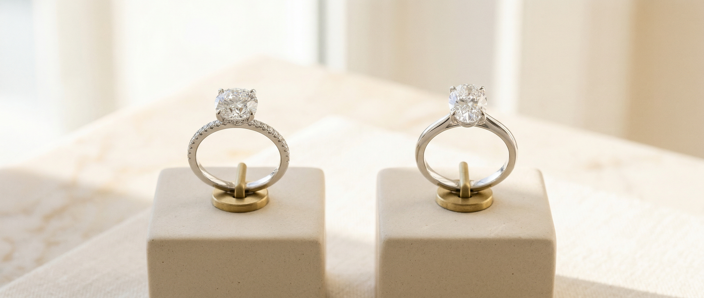 Two diamond rings on display stands with a blurred background