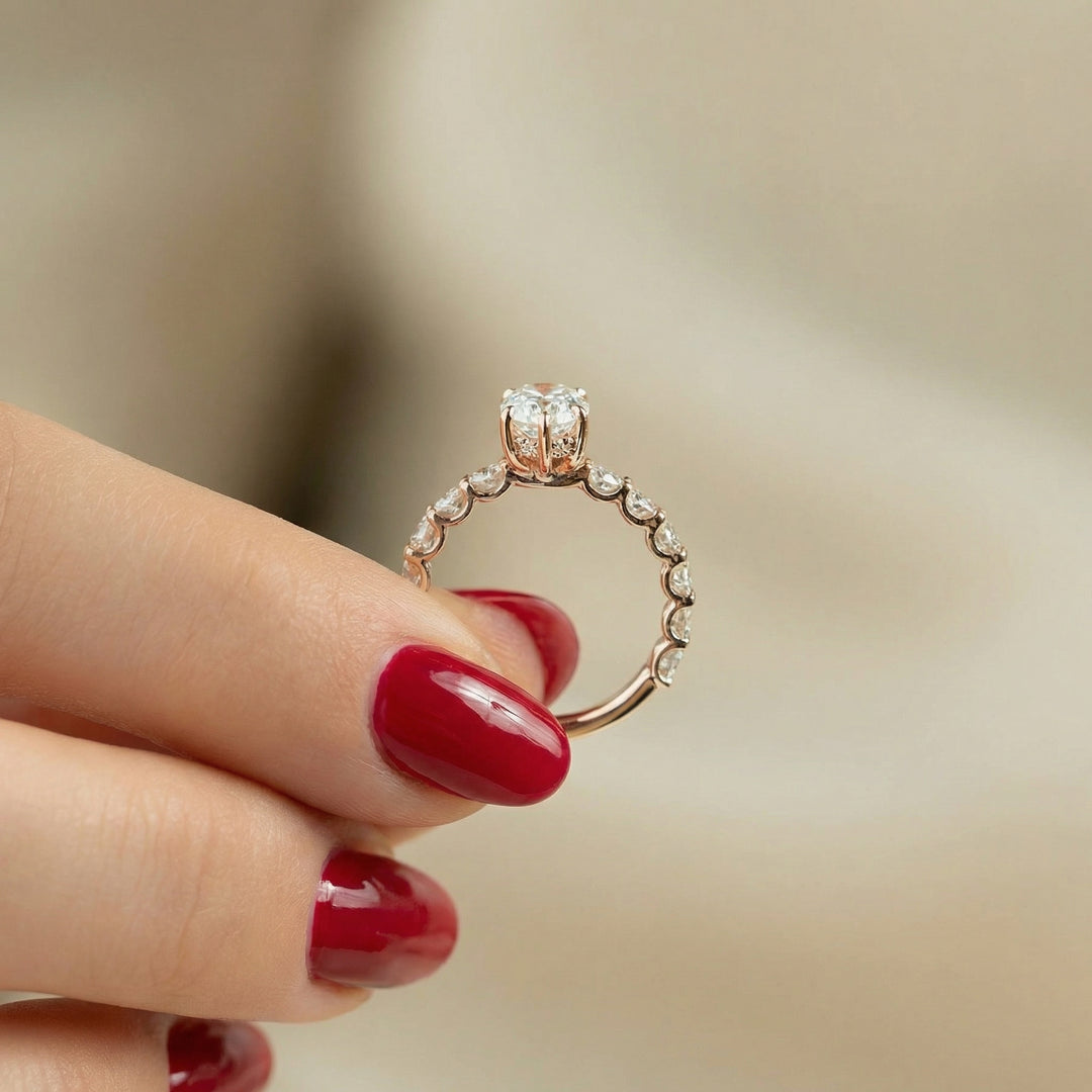 Gold ring with diamonds held between fingers against a blurred background #material_rose