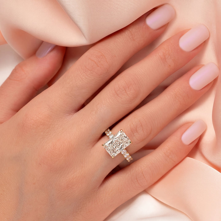 Close-up of a hand wearing a diamond ring with another ring on a soft background #material_gold