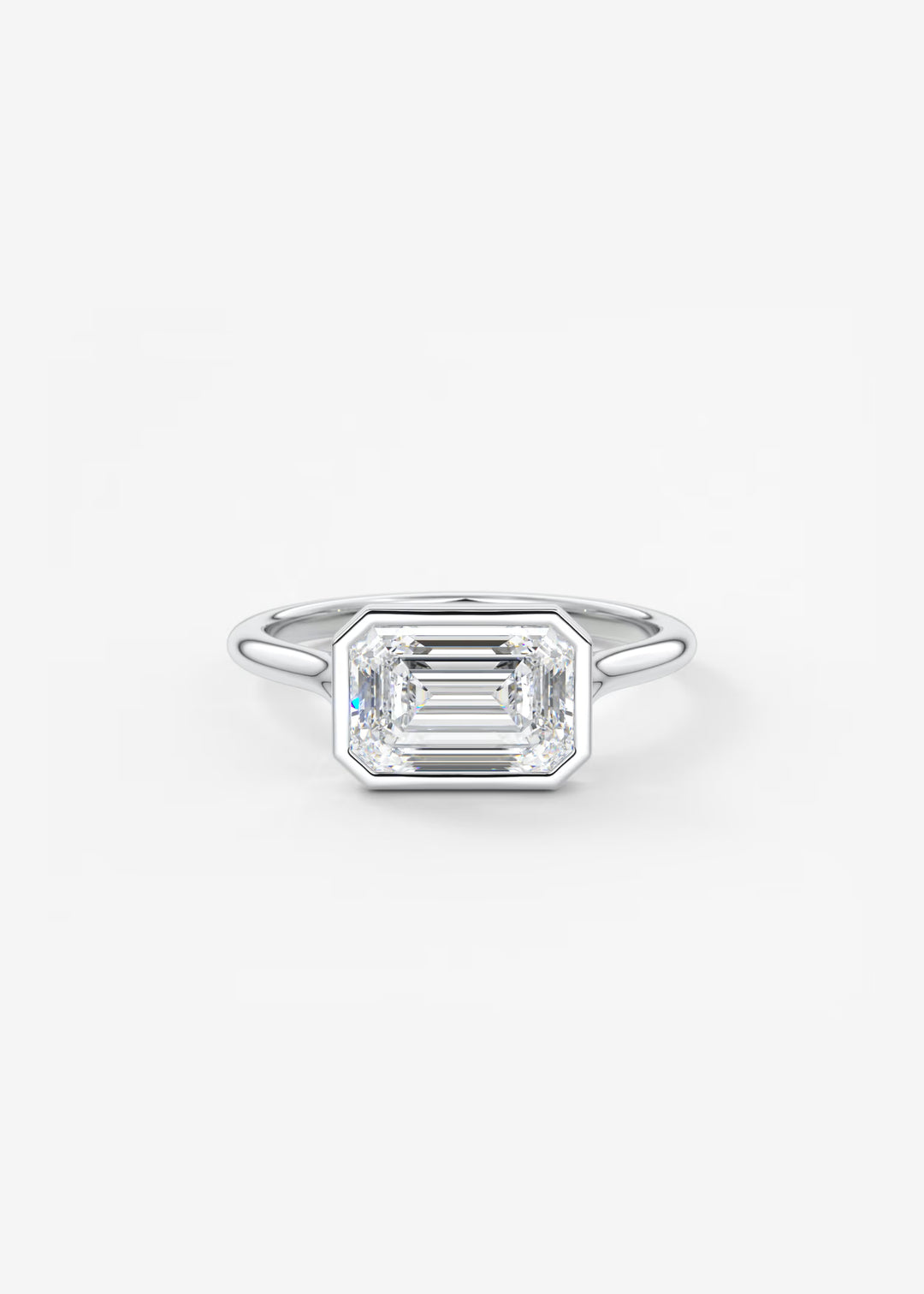 An emerald-cut diamond ring in a silver-toned metal band, centered on a clean white background. #material_white