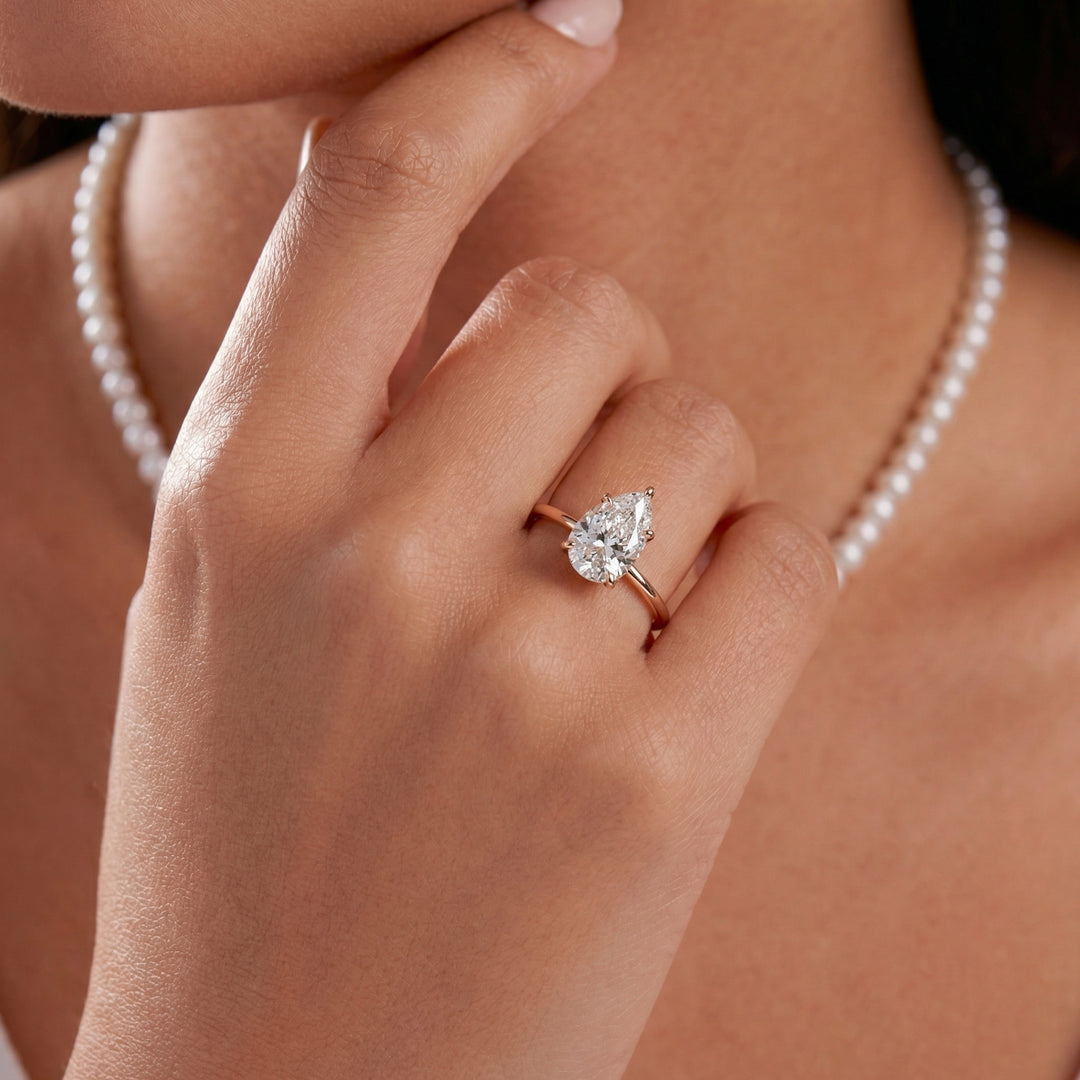 Hand wearing a rose gold diamond ring #material_rose