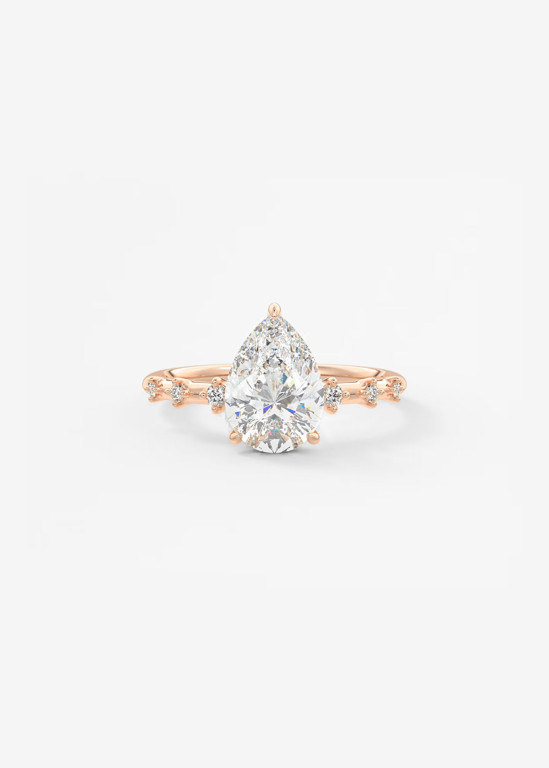 A pear-cut diamond engagement ring in rose gold with small accent diamonds on the band, set against a clean white background.#material_rose