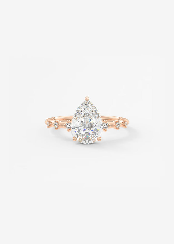 A pear-cut diamond engagement ring in rose gold with small accent diamonds on the band, set against a clean white background.#material_rose