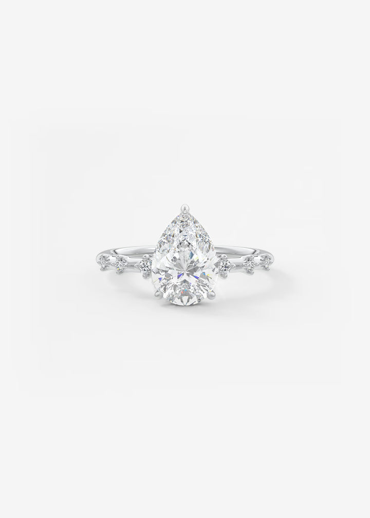 A pear-cut diamond engagement ring with a silver-toned diamond-accented band, centered on a clean white background.#material_white