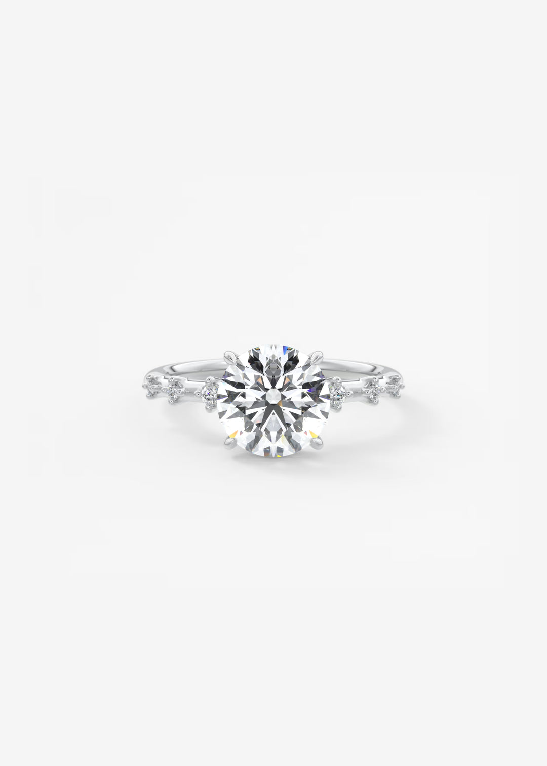 A silver-toned diamond engagement ring featuring a round-cut center stone and smaller diamonds along the shoulders, set against a plain white background.#material_white