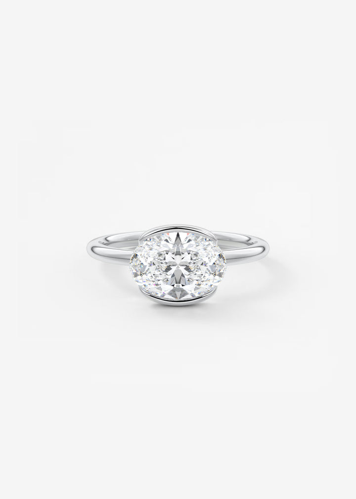 A classic diamond engagement ring with a round brilliant-cut center stone in a four-prong setting on a polished silver band, shown against a clean white background.#material_white