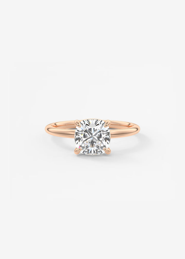 A rose gold solitaire engagement ring with a round brilliant-cut diamond center stone, shown on a clean white background.#material_rose