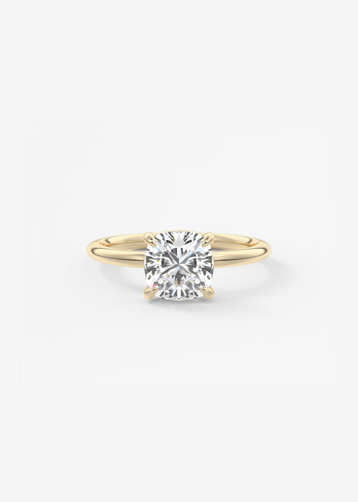 A yellow gold solitaire engagement ring with a round brilliant-cut diamond, shown on a clean white background.#material_gold