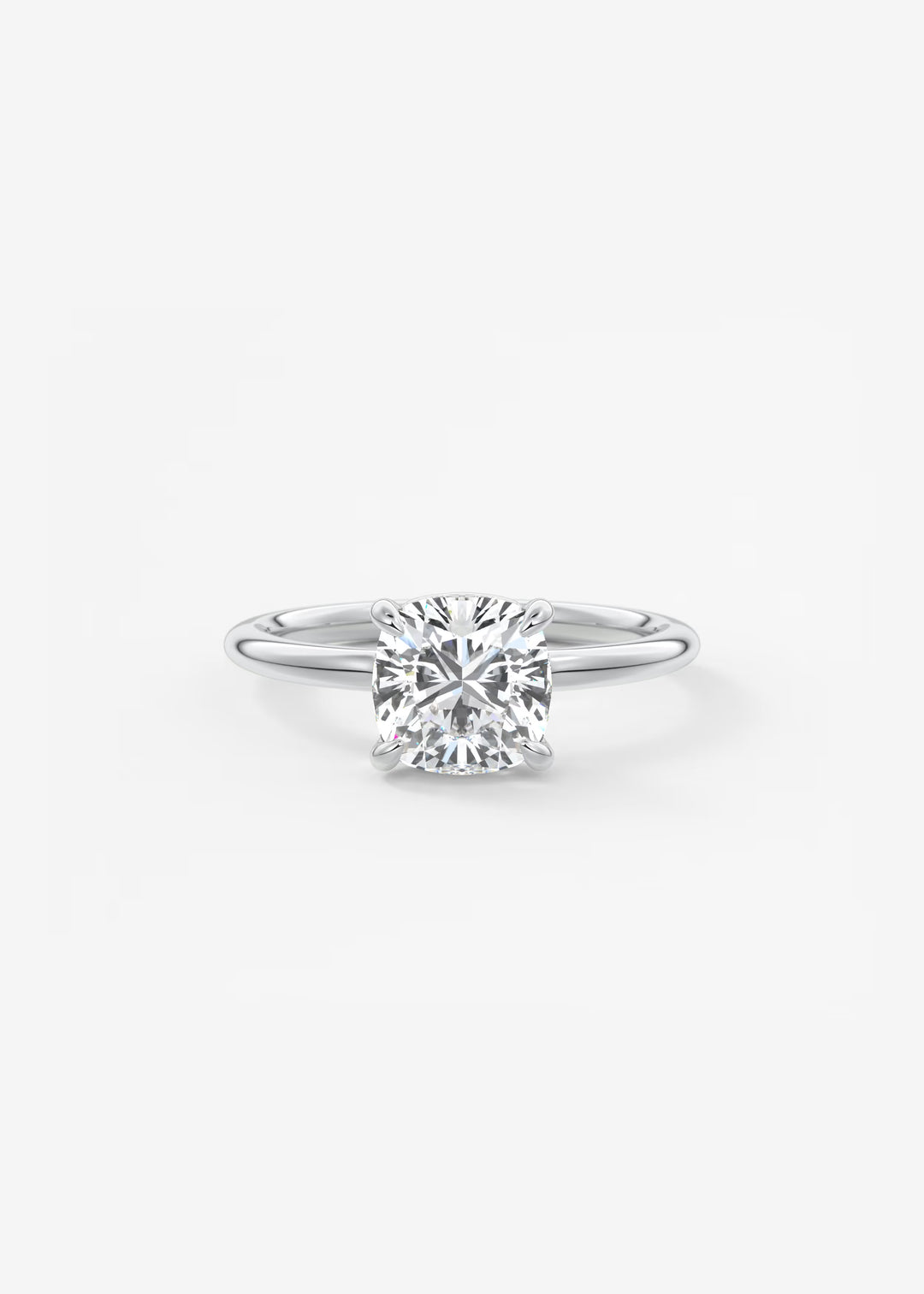 A classic solitaire engagement ring featuring a round brilliant-cut diamond set in a polished silver-colored metal band, centered on a clean white background.#material_white