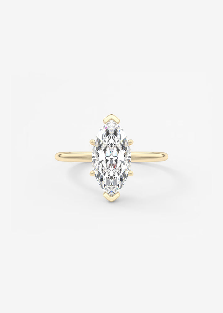 A yellow gold ring featuring a marquise-cut clear gemstone in a prong setting, centered on a light gray background.#material_gold