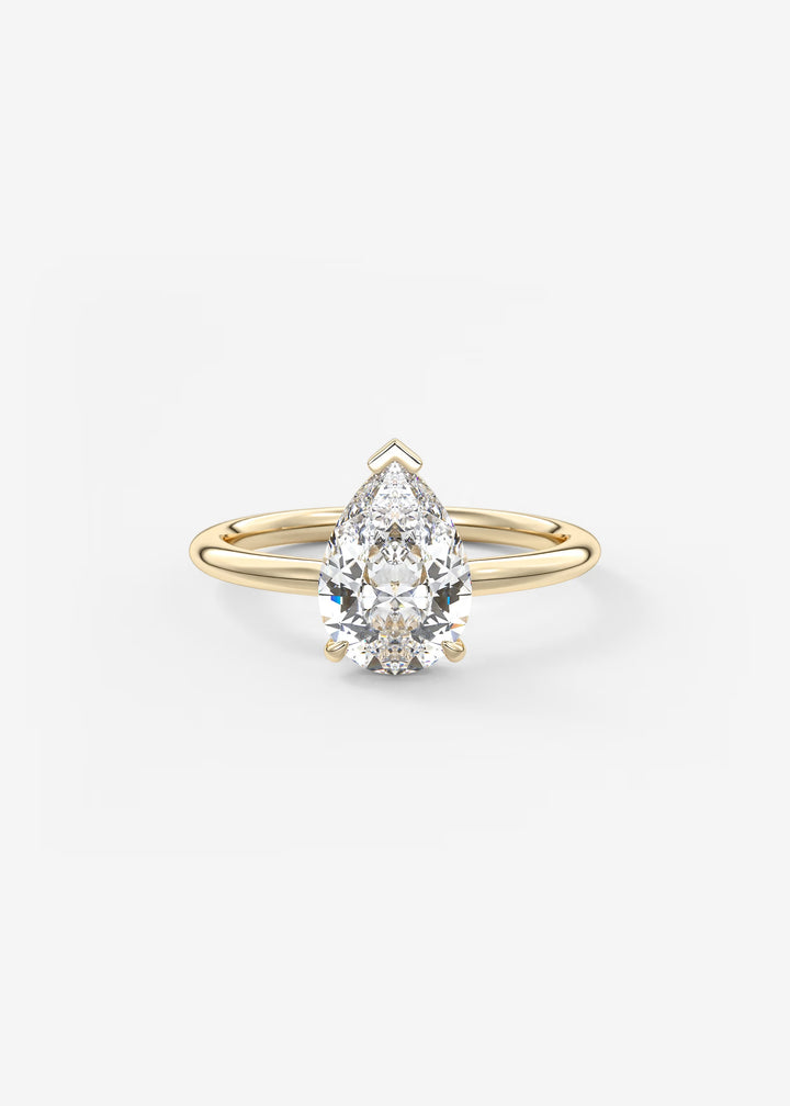 A pear-cut diamond engagement ring with a yellow gold band, shown on a clean white background.#material_gold