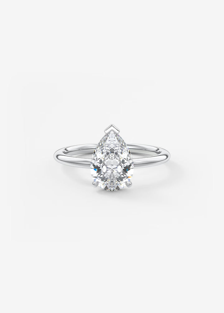 A pear-cut diamond engagement ring in a silver-toned solitaire setting, centered on a clean white background.#material_white