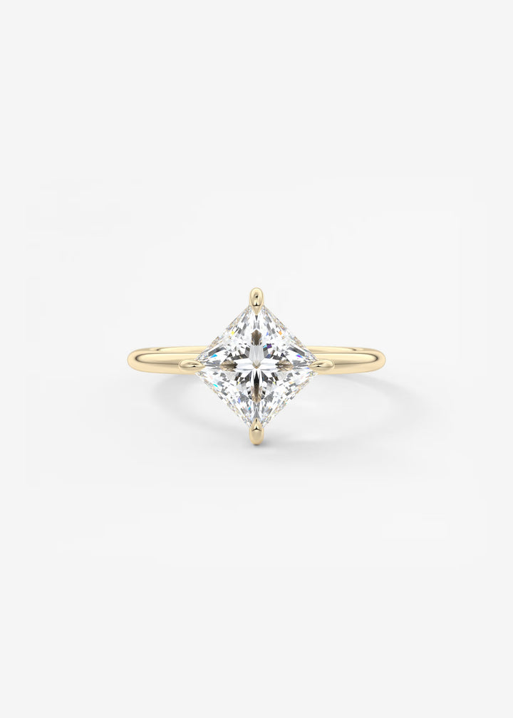 A yellow gold ring featuring a large, brilliant-cut diamond in a four-prong setting, centered on a clean white background.#material_gold