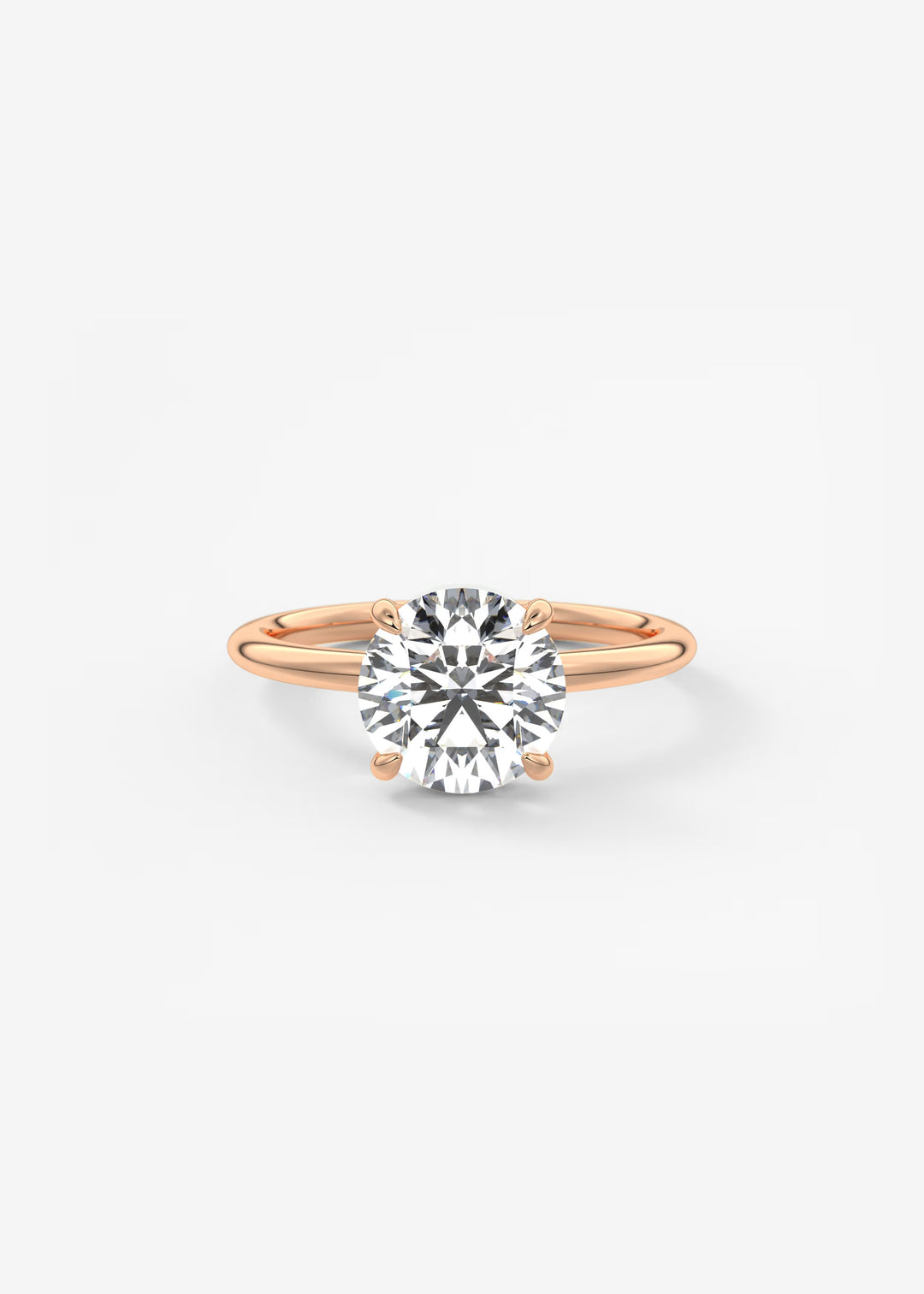 A classic solitaire engagement ring featuring a round brilliant-cut diamond set in a rose gold four-prong setting on a polished band, centered against a clean white background.#material_rose