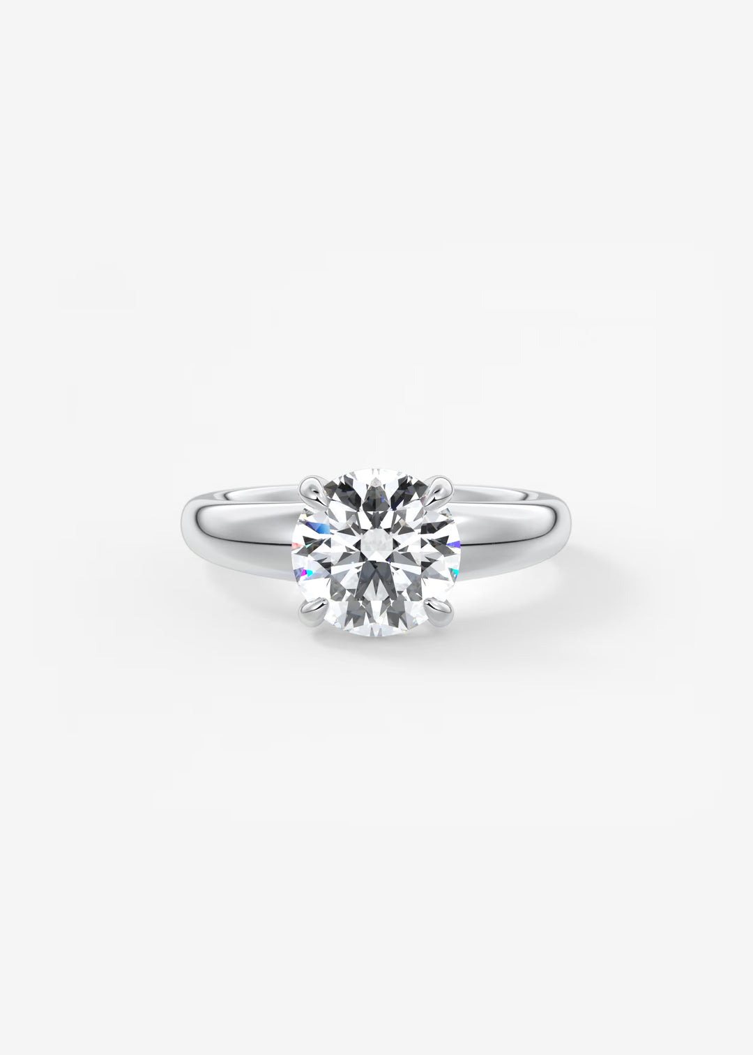 A classic solitaire engagement ring featuring a round brilliant-cut diamond set in a polished silver-colored band, presented on a clean white background.#material_white