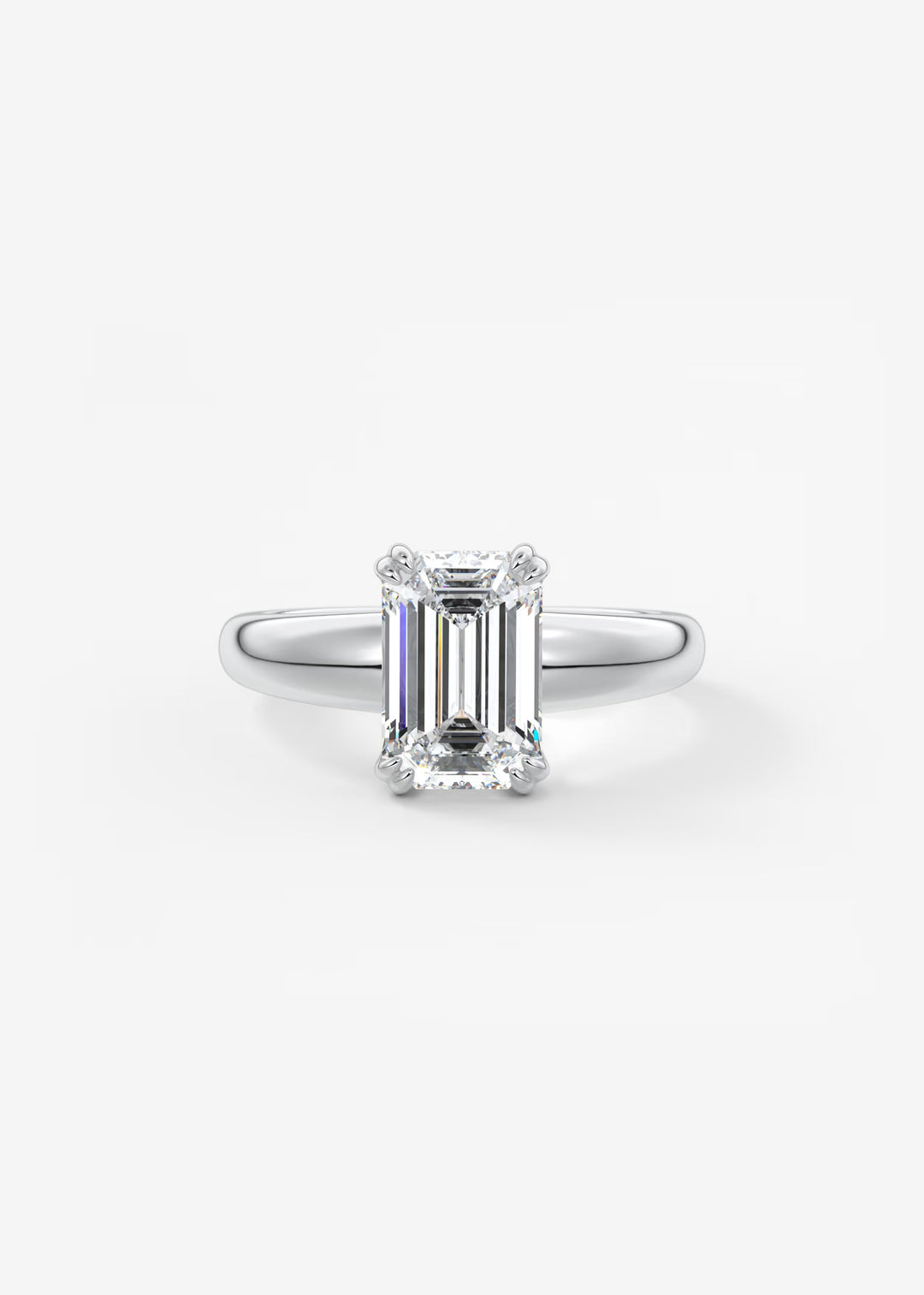An emerald-cut diamond ring in a silver four-prong setting, centered on a clean white background.#material_white