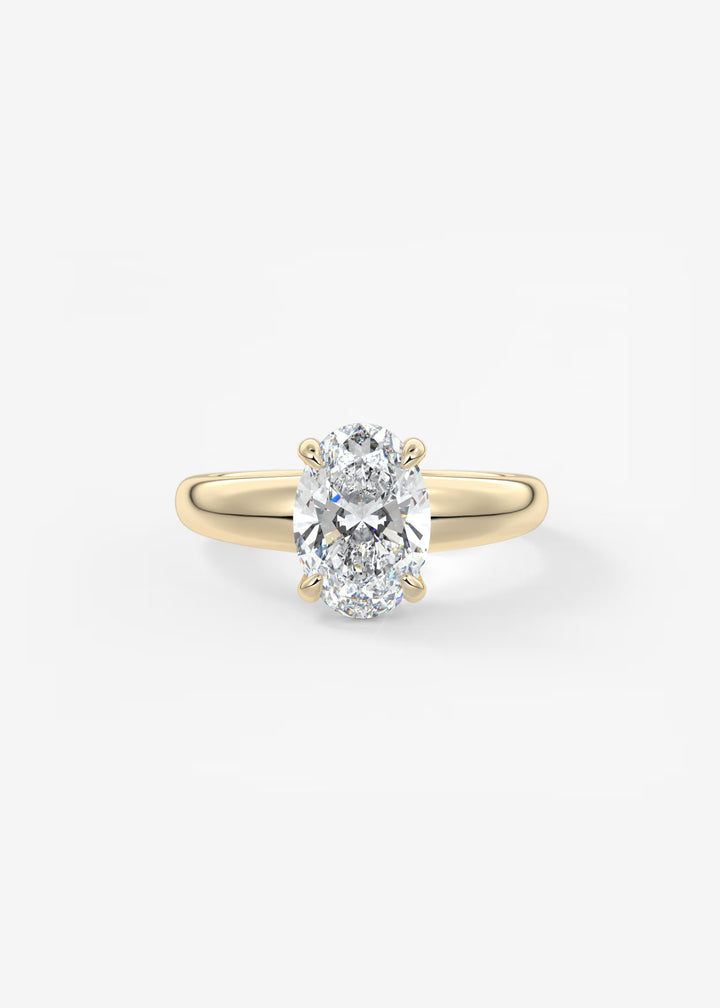 An oval-cut diamond engagement ring with a yellow gold band, shown on a clean white background.#material_gold