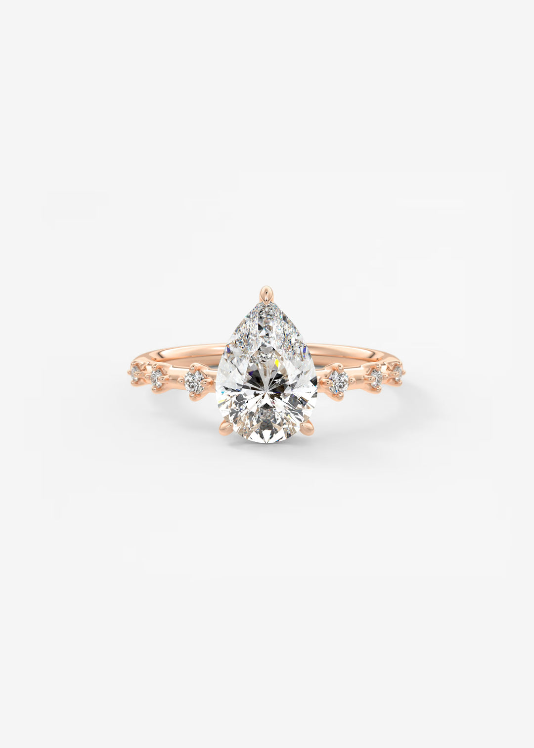 A pear-cut diamond engagement ring in rose gold, featuring a central diamond and smaller diamonds along the shoulders of a delicate rose gold band, set against a clean white background.#material_rose