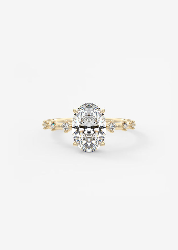 A yellow gold engagement ring featuring a large oval-cut center stone and smaller accent stones along the shoulders, set against a plain white background.#material_gold