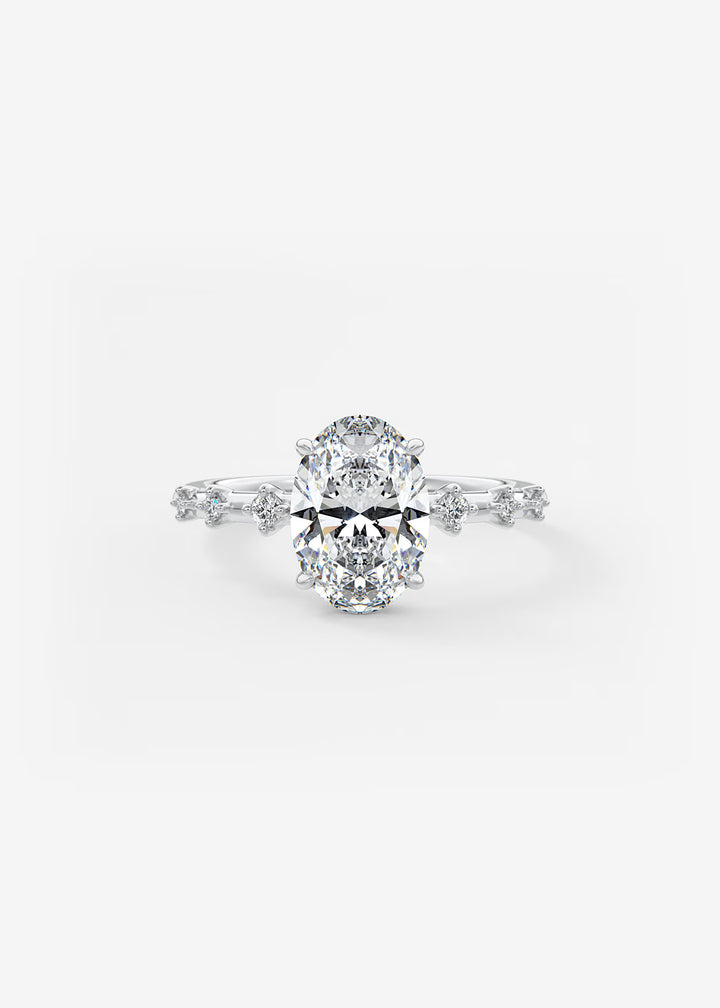 A radiant cut diamond engagement ring in a silver-colored setting with a halo design and small accent diamonds along the band, shown on a clean white background.#material_white