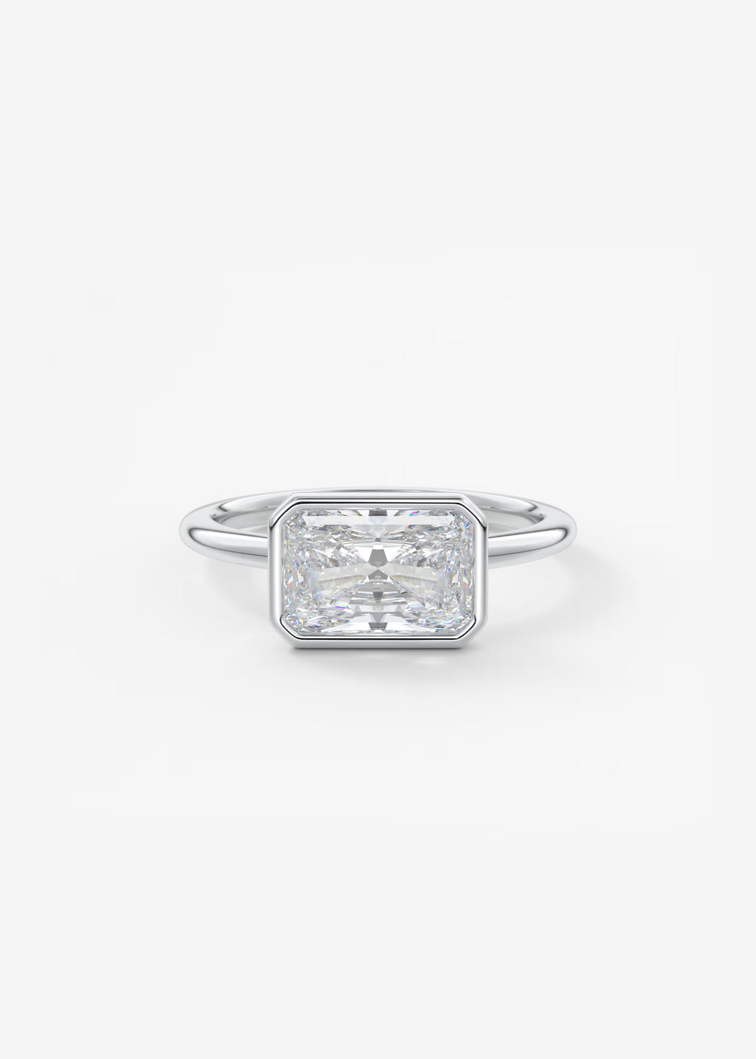 An emerald-cut diamond engagement ring in a silver-toned metal band, centered on a clean white background.#material_white