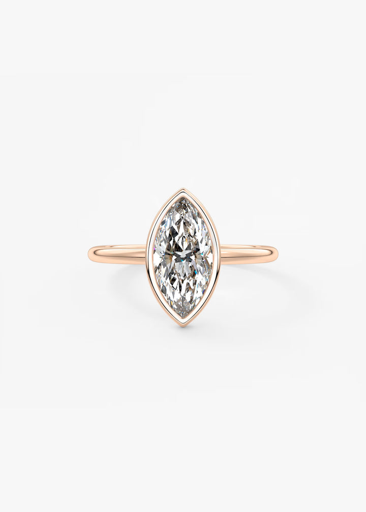 A yellow gold ring featuring a marquise-cut diamond in a bezel setting, centered on a clean white background.#material_rose