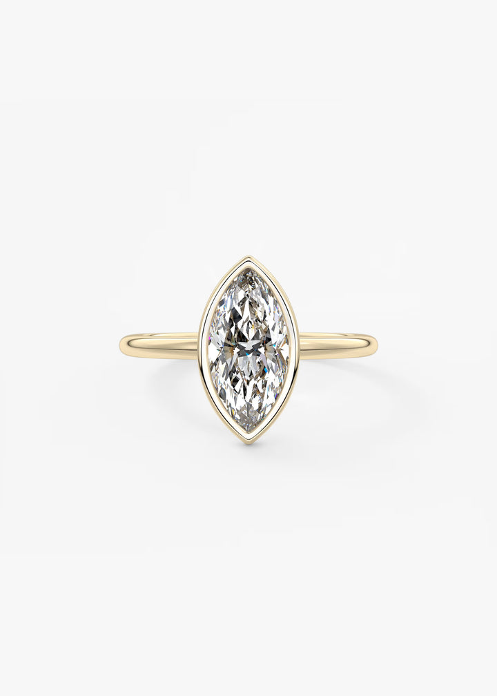 A yellow gold ring featuring a marquise-cut diamond in a bezel setting, centered on a clean white background.#material_gold