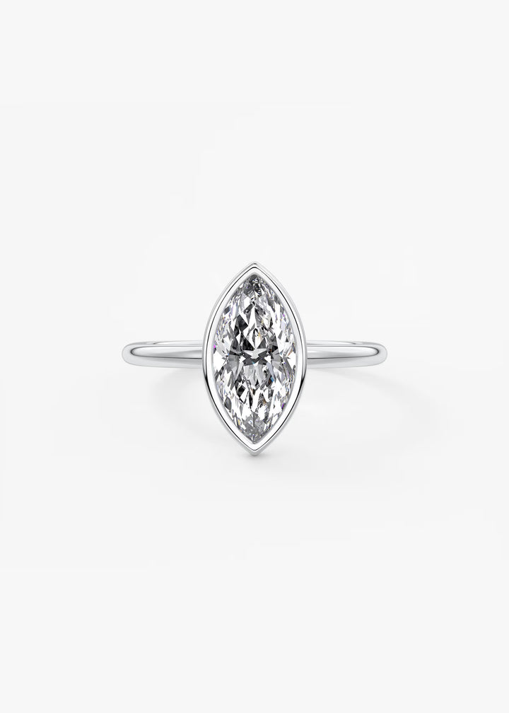 A silver-tone ring featuring a marquise-cut clear gemstone in a prong setting, centered on a plain light gray background.#material_white