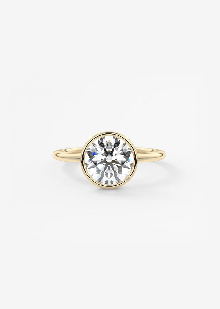 A yellow gold ring featuring a large, round brilliant-cut clear gemstone in a bezel setting, shown against a plain white background.#material_gold