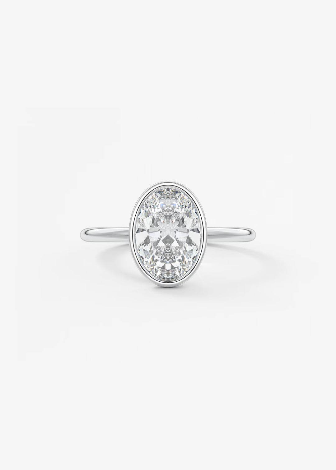An oval diamond engagement ring with a silver-colored band, set against a clean white background.#material_white