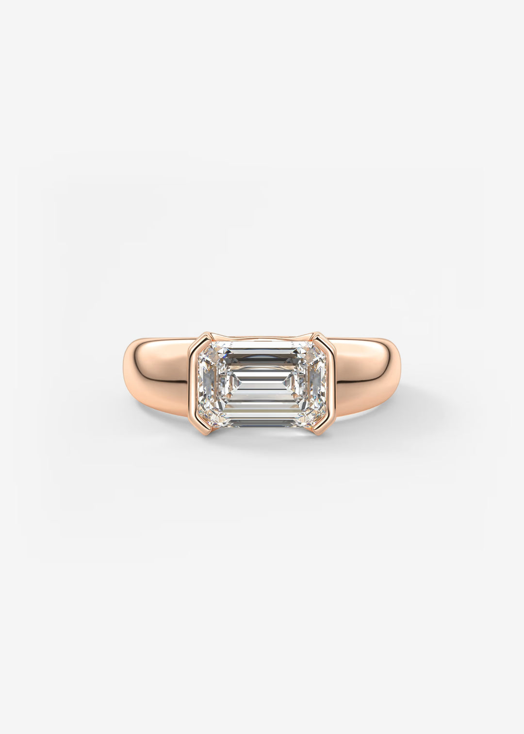 A rose gold ring featuring an emerald-cut clear gemstone in a four-prong setting, shown against a plain light gray background.#material_rose