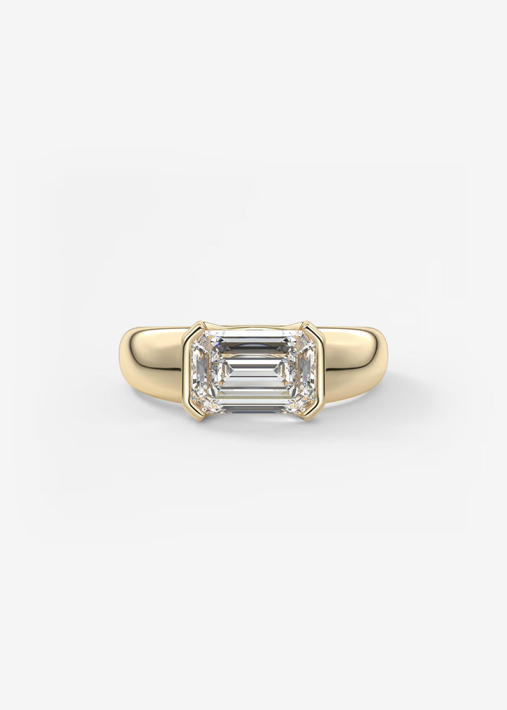 Gold ring with emerald-cut diamond on a white background#material_gold