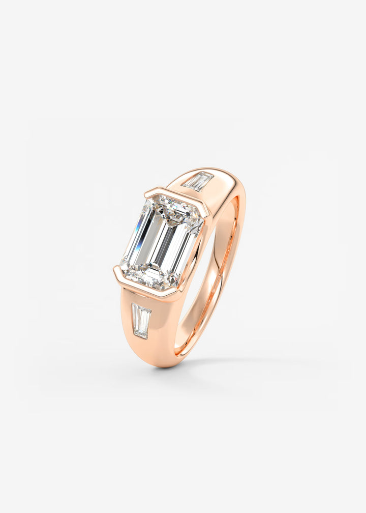 The Lune Trio Emerald Cut Half Bezel Three Stone Engagement Ring with Peekaboo Gallery and Tapered Baguettes#material_rose