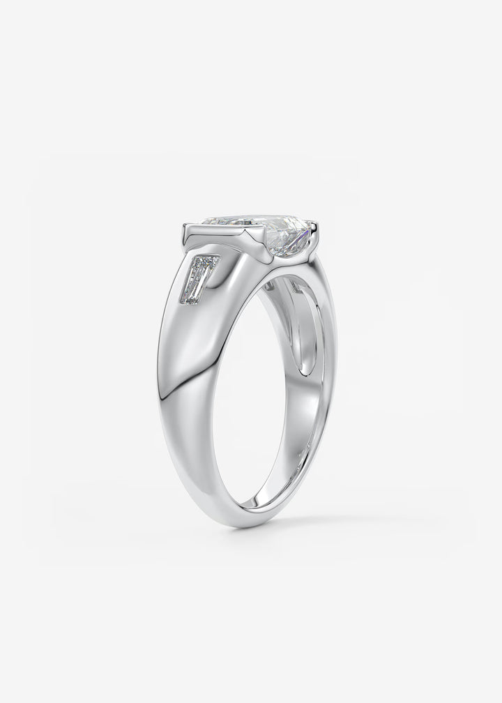 The Lune Trio Emerald Cut Half Bezel Three Stone Engagement Ring with Peekaboo Gallery and Tapered Baguettes#material_white